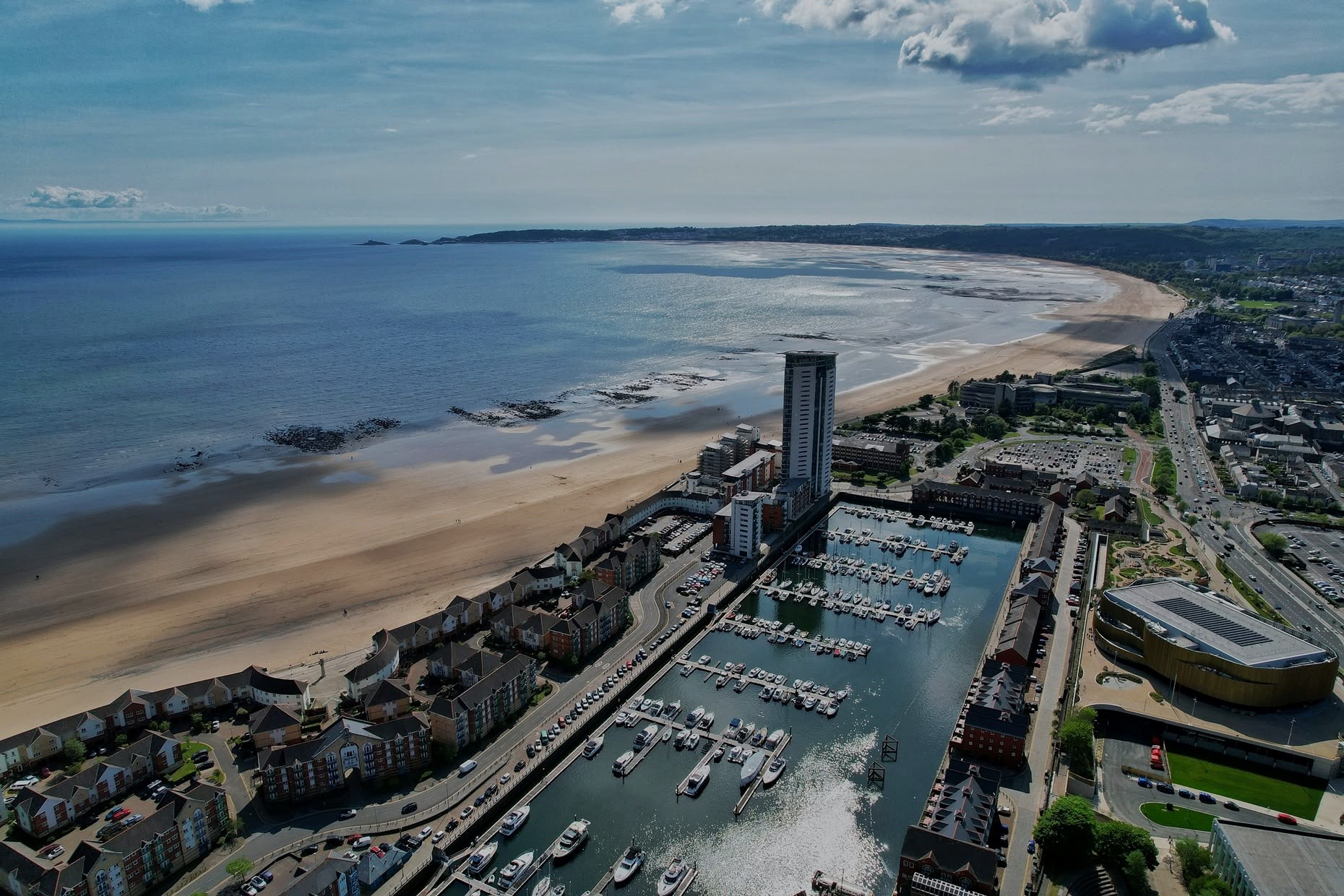 Aerial view of Swansea Bay, with the marina and Meridian Tower in the foreground and the beach curving towards Mumbles